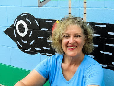 Dianna Hodges - President, by painted wall