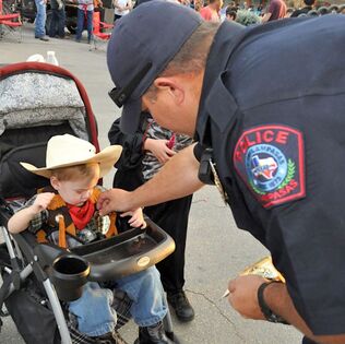 Policeman and a little costumed cowboy